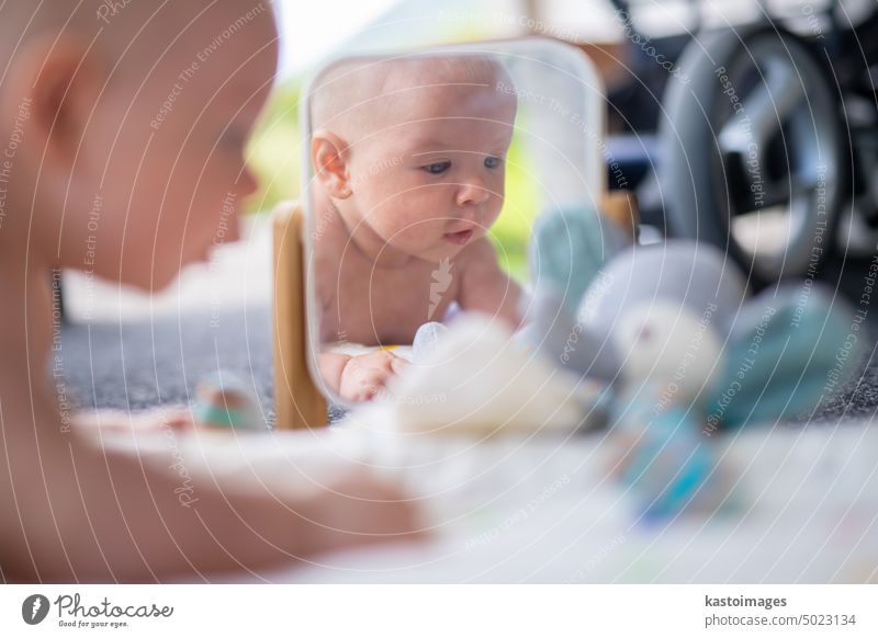 Beautiful shot of mirror reflectiona of cute baby boy playing with toys. child portrait infant childhood beautiful adorable emotion smile happy innocent