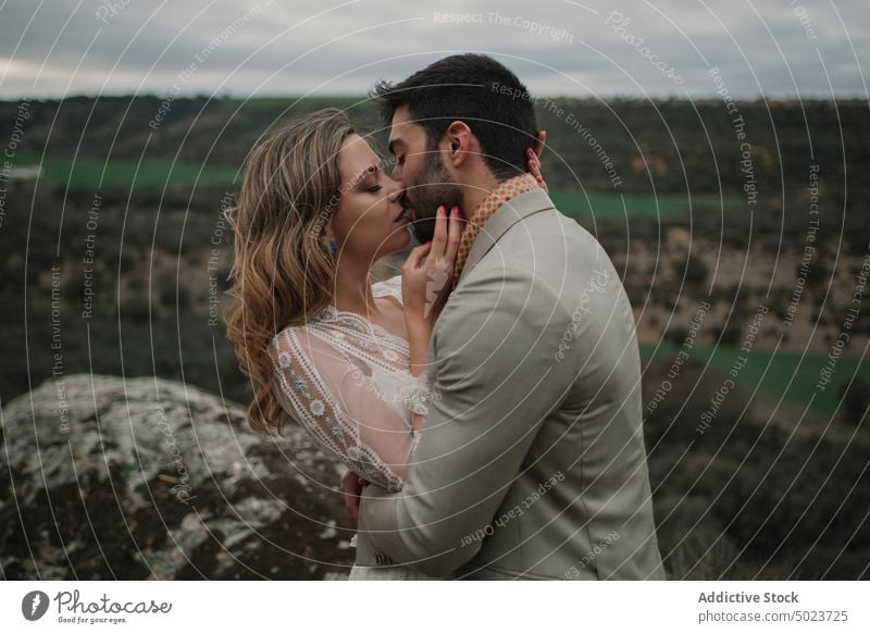 Man hugging with woman on hill and view on valley valentine dress wedding couple lady guy suit embracing picturesque landscape mountain top cloudy young looking