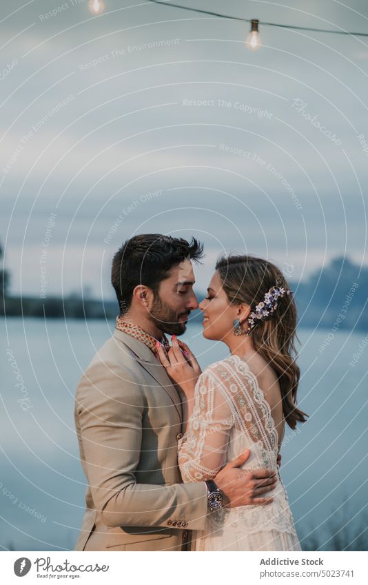 Man hugging bride near lake at night man woman kissing valentine wedding couple lady guy dress suit embracing closed eyes young love marriage party attractive