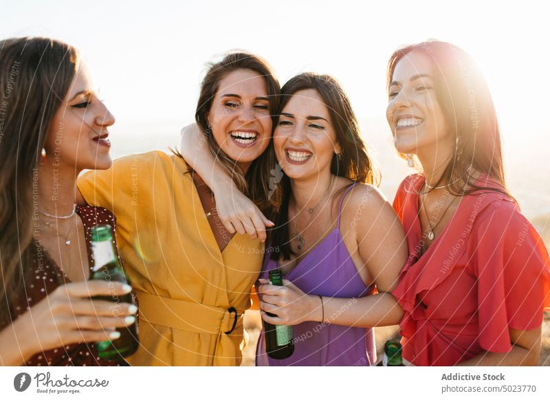 Happy girlfriends with drinks having fun on hilltop women party alcohol booze beverage cheerful happy town cloudless sunlight joy female move activity glee