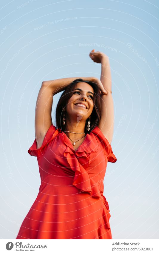 Cheerful woman red dress against blue sky freedom happy style cloudless smile toothy smile outfit necklace content black hair cheerful female joy positive