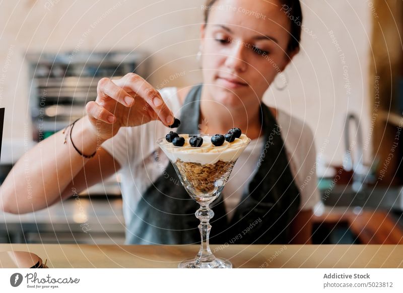 Woman preparing fruit and berry dessert woman waitress food sweet bowl fresh organic blueberry meal nutrition red natural cereal vegetarian cream delicious
