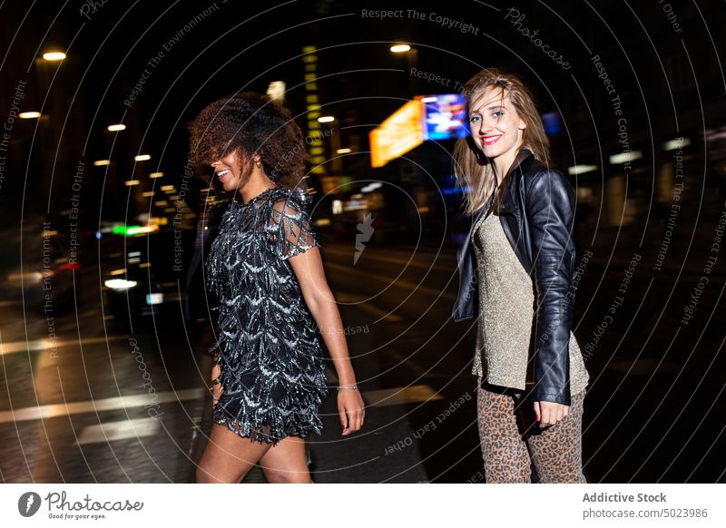 Diverse smiling friends walking on street at night women party cheerful style fun cool relax holiday gather happy celebrate event nightlife positive carefree