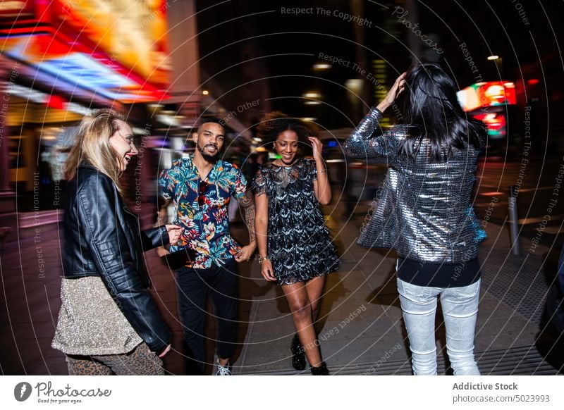 Diverse smiling friends walking on street at night women man party cheerful style fun cool holiday gather happy celebrate event nightlife positive carefree