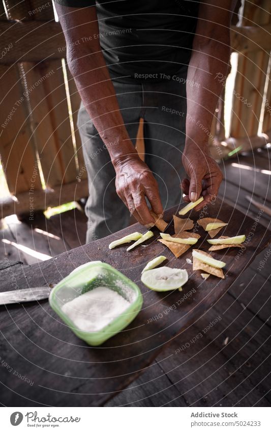 Crop ethnic man preparing Mexican appetizer at table cook nacho avocado tradition mexican food countryside snack male hispanic cut knife slice meal tasty