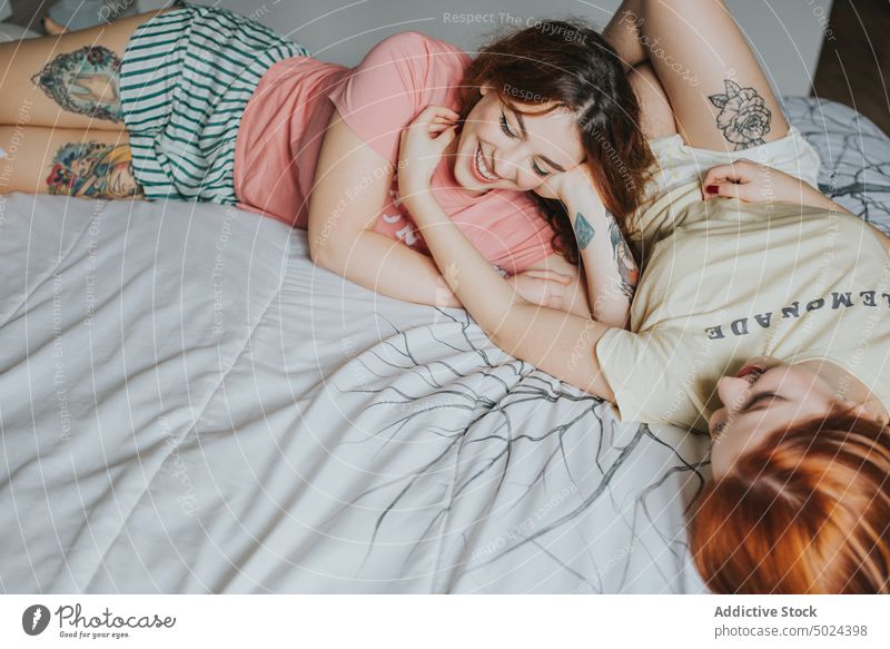 Women With Tattoos Resting On Bed bed bedroom indoors pillow woman comfort leisure alternative anonymous art bedding couple cozy crop faceless female friend