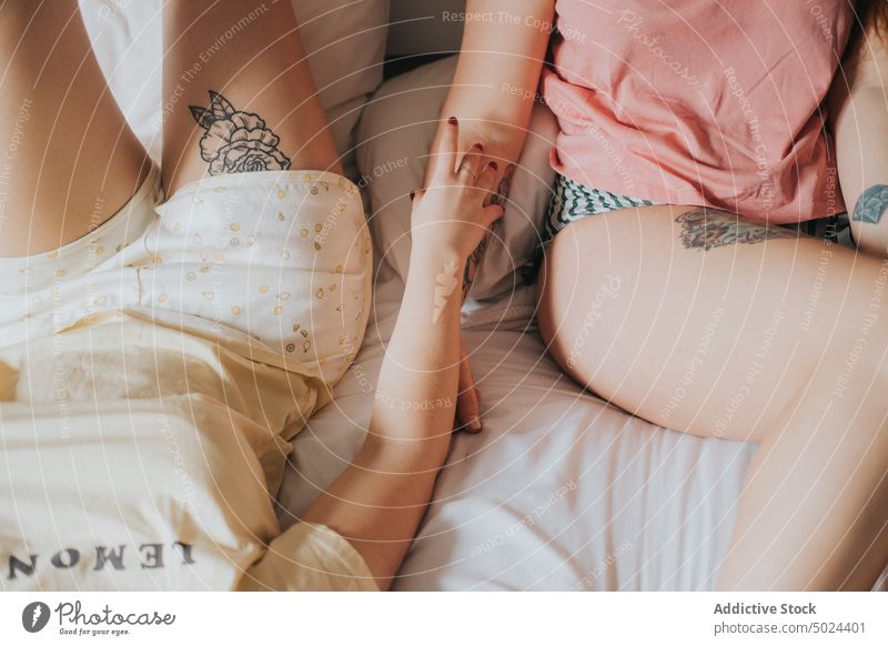 Women With Tattoos Resting On Bed woman bed indoors young bedroom alternative anonymous art bedding comfort couple cozy crop faceless female friend friendship