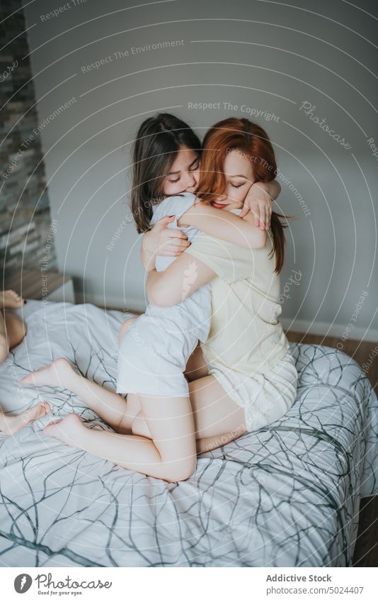 Woman Hugging Girl On Bed girl woman indoors child love bed bedroom care childhood closed eyes comfort cozy domestic embracing female happiness home hugging