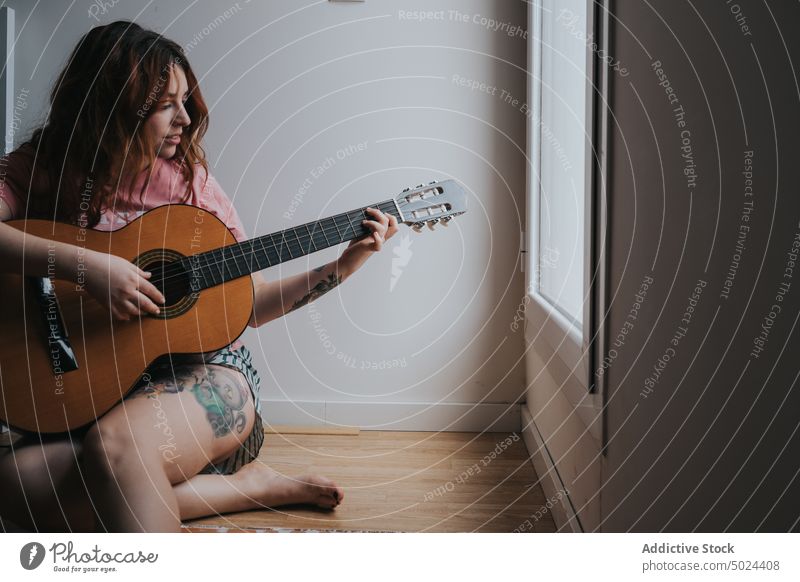 Young Smiling Woman With Guitar Sitting At Home music woman guitar indoors instrument acoustic attractive beautiful darkness domestic female home interior