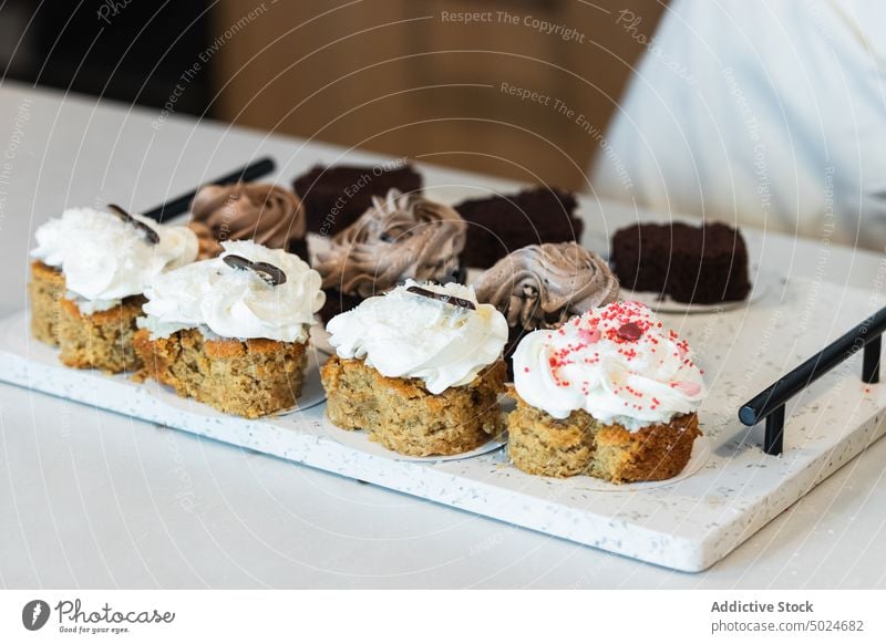Appetizing carrot cakes on tray in kitchen dessert assorted bakery whipped cream vegan delicious various cuisine gourmet fresh palatable patisserie appetizing