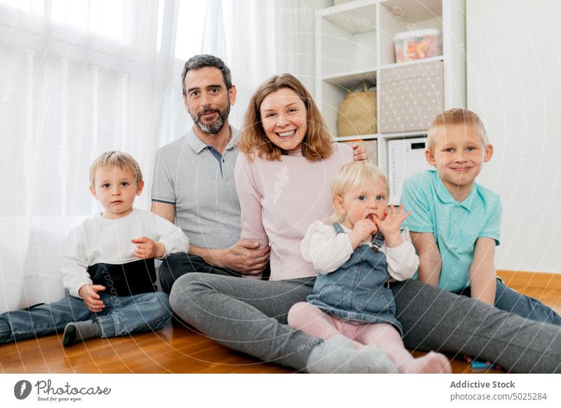 Cheerful family clapping hands on floor at home children having fun cheerful childhood weekend parenthood house portrait parquet spend time happy daughter son