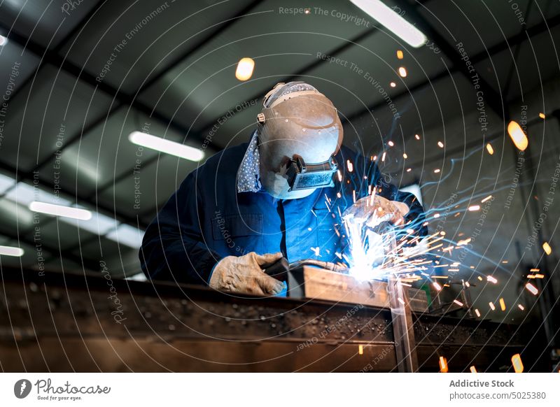Professional welder in protective helmet in workshop metal man machine dark spark light male worker occupation professional tool industry job equipment labor