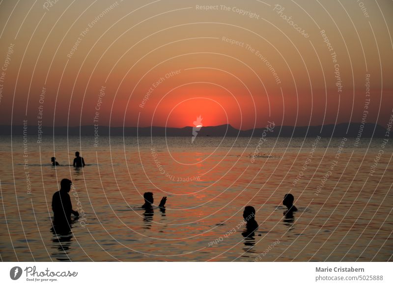 Silhouettes of people enjoying the warm sea during the sunset in Koh Tonsay or Rabbit Island in Cambodia lifestyle people silhouettes leisure recreation tourism