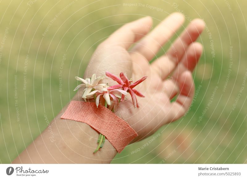 Conceptual photo of flowers plastered on a wrist showing suicide awareness, mental health and wellness concept healing wellbeing bright airy freedom