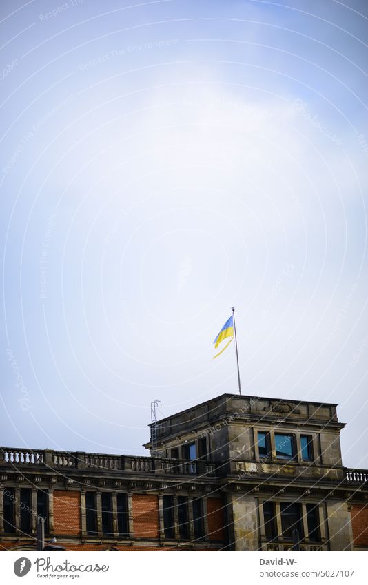 Torn Ukrainian flag on a building Ukraine Destruction torn Flag Broken War Sign symbol Building Ukraine war