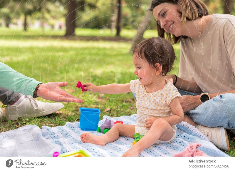 Smiling mother with baby sitting on grass daughter tender bonding babyhood park fondness lawn carefree woman mom girl nature together child little smile