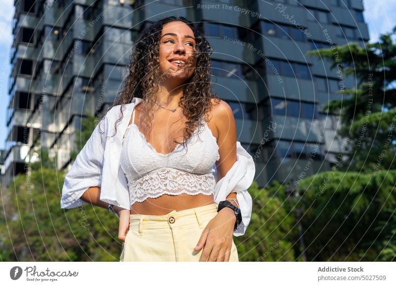 Young Hispanic woman in park smile summer style happy street weekend daytime urban female hispanic ethnic young cheerful glad hand on waist positive carefree