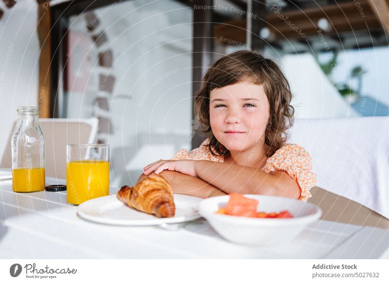 Content child having breakfast in cafe girl cafeteria table delight chill nutrition content glass orange juice croissant food kid healthy yummy natural nutrient