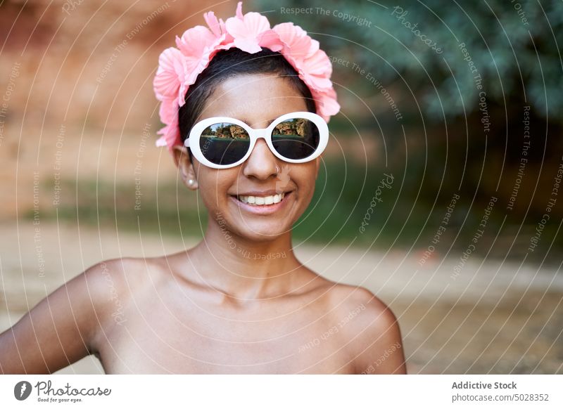 Cheerful Hispanic tourist with sunglasses and wreath woman smile style summer beach weekend vacation portrait female young hispanic ethnic happy accessory