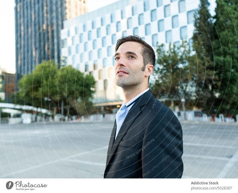 Well dressed young businessman looking away on city street thoughtful respectable well dressed confident manager building classy entrepreneur formal male brunet