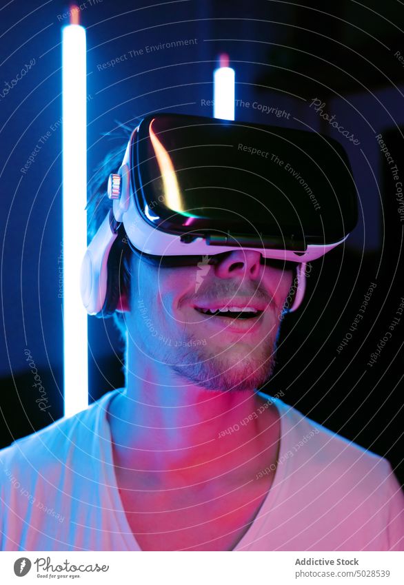 Amazed male in VR headset in neon lights man virtual reality vr goggles glasses immerse excited amazed portrait technology illuminate glow hi tech high tech
