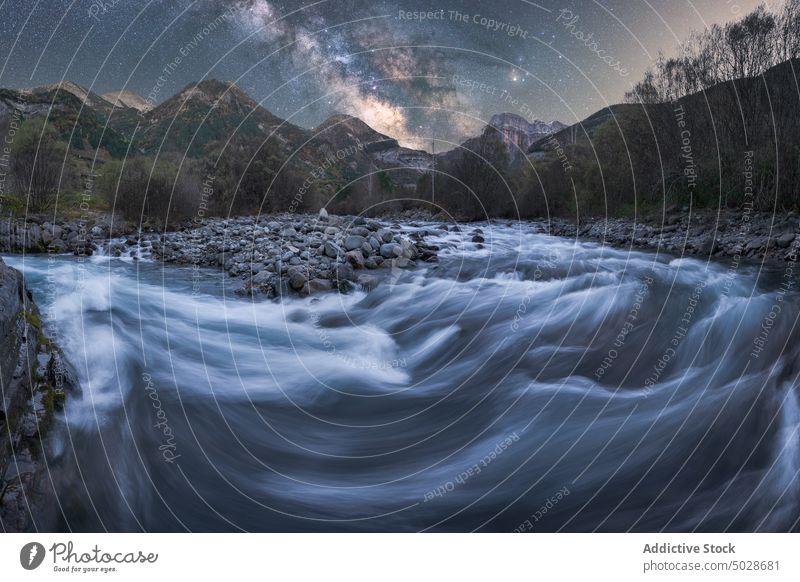 Fast river near mountains and forest under starry sky at dusk milky way autumn nature water rock tree national park stream creek weather formation long exposure