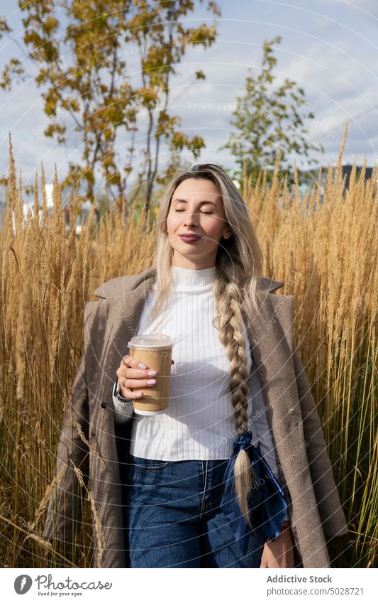 Woman with takeaway beverage enjoying sunlight woman drink grass style urban weekend calm female to go nature summer eyes closed braid long hair blond coffee