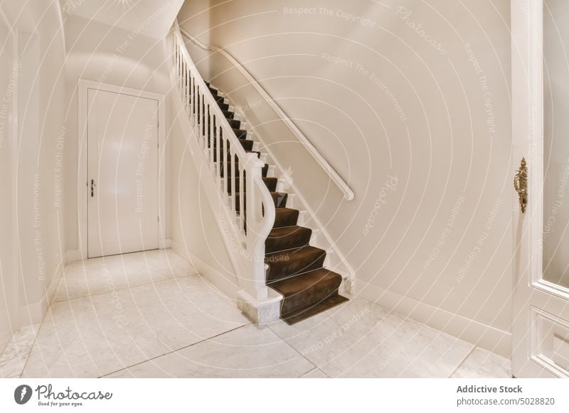 White corridor with staircase hallway design apartment home house door passage residential dwell marble tilled indoors doorway stairway tile property wall
