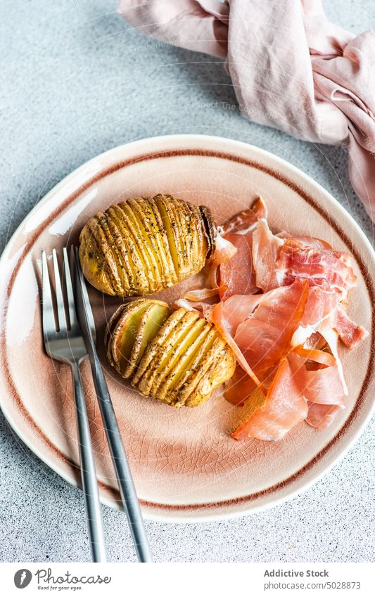 Baked potato with herbs and spices bacon baked cabbage cooked cooking dinner eat food gourmet hasselback healthy meal oil organic background pink concrete