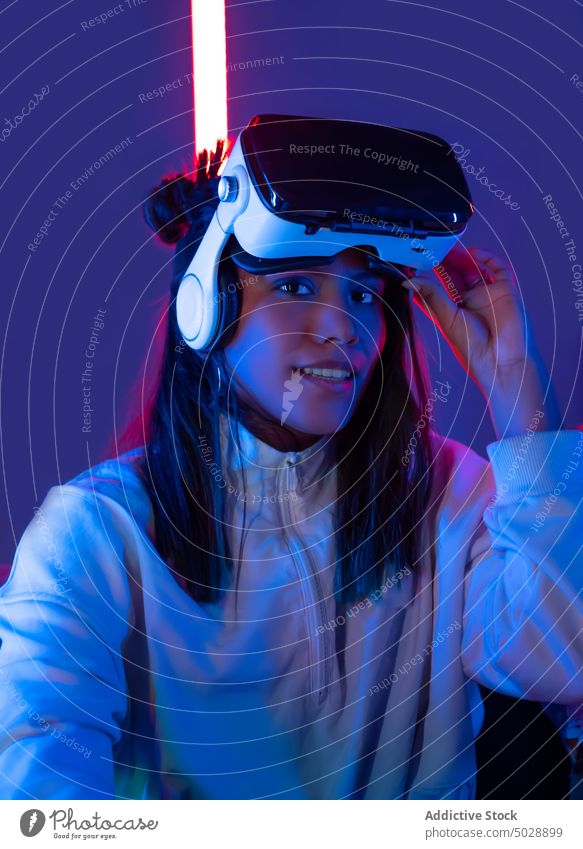Lady in VR goggles against neon lights woman virtual reality headset vr glasses immerse futuristic technology interact female illuminate glow luminous equipment