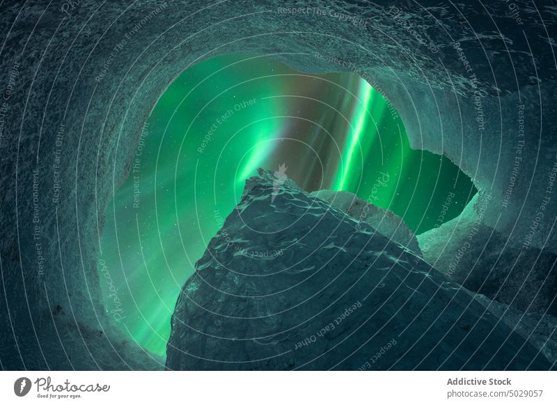 Amazing view of aurora borealis throughout hole in ice cave peak northern formation sky winter cold iceland vatnajokull mountain national park glacier