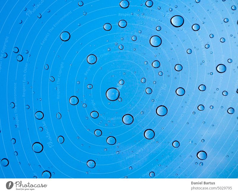 Drops of destilled water on the car's glass roof blue bubbles details drops sky wallpaper