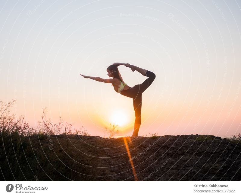 Silhouette young woman practicing yoga on the beach above sea at amazing sunset. fitness, sport, yoga and healthy lifestyle concept nature sunrise body energy