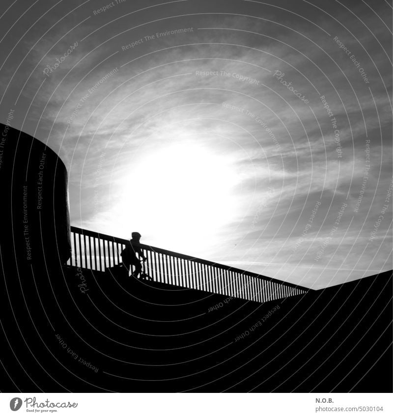 Cyclist backlit in black and white Black & white photo black-and-white black and white in color Exterior shot B/W Sunlight Back-light Backlight shot