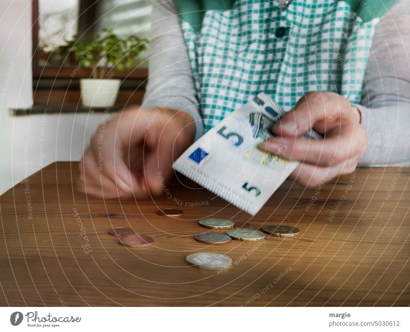 A housewife counts her money Housewife Pensioner Numbers Money Poverty finance Save Loose change Coins Euro Paying Cent Hand Close-up payment apron dress