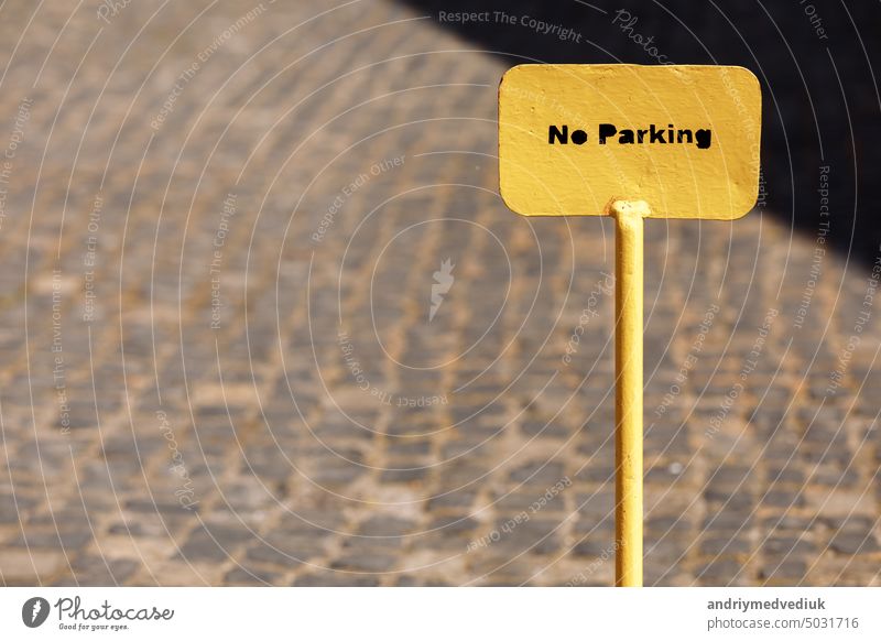 Yellow metal No parking sign on road. selective focus. yellow warning street caution no parking safety wall transportation urban background outdoors message