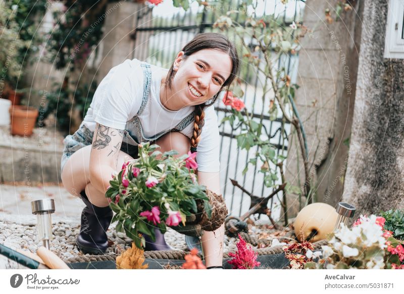 Portrait of a young gardener on her house garden taking care of the flowers, new home activities. woman gardening greenhouse caucasian female growing job