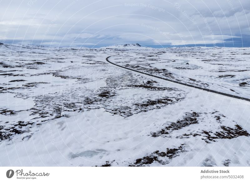 Empty asphalt road amidst field covered in snow winter landscape night polar aurora Iceland breathtaking ridge highland cold scenery picturesque meadow highway