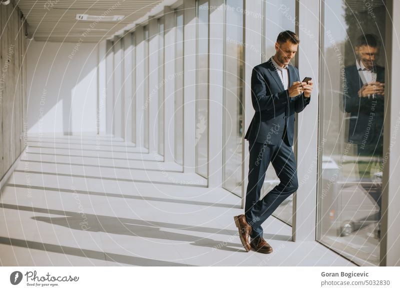Young business man using mobile phone in the modern office hallway smartphone building space professional executive communication businessman telephone person