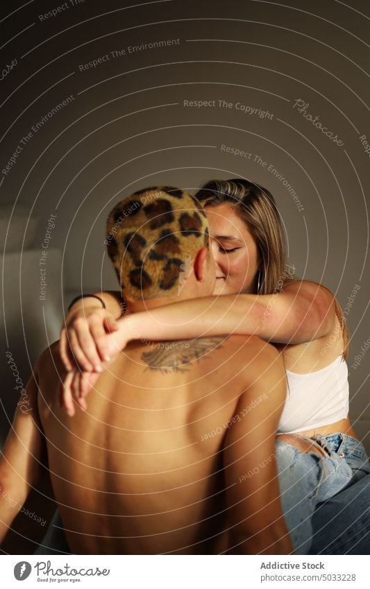 Young couple hugging at home love sunlight relationship together tender close touch boyfriend girlfriend young subculture shirtless dyed hair tattoo informal
