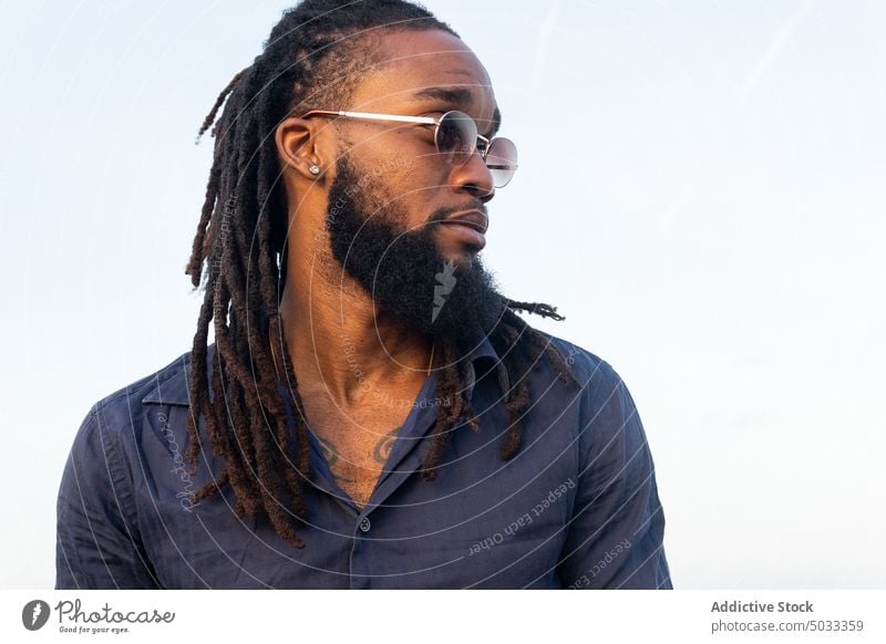 African American man against cloudy sky style tranquil dreadlocks appearance serene male harmony guy ethnic stand idyllic hairstyle beard lifestyle peaceful