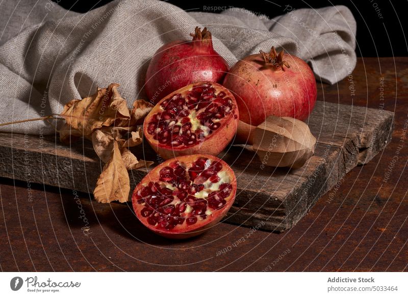Ripe pomegranate on wooden board ripe fruit dark seed arrangement fresh healthy food gourmet meal natural organic whole color nutrition squeezer chopping board
