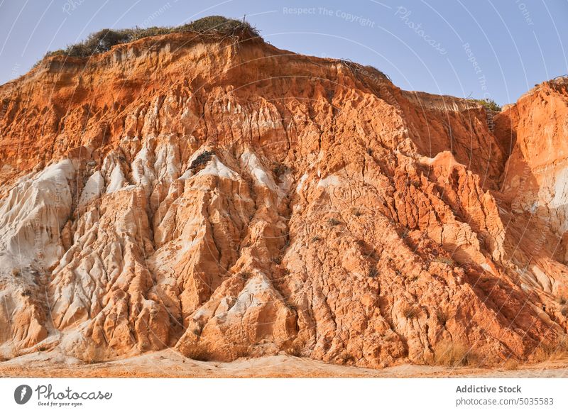 Sandstone cliff against blue sky beach sandstone rough daytime geology formation nature coast falesia algarve portugal summer shore picturesque cloudless sky