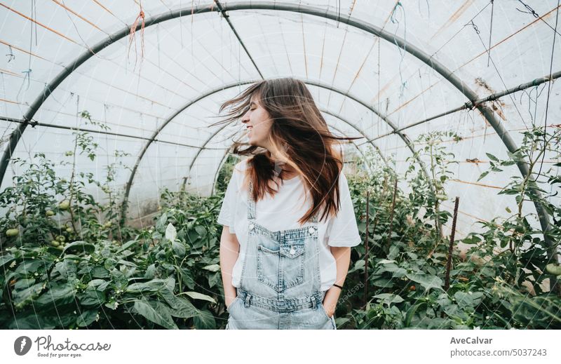 Woman moving hair standing in the middle of a greenhouse during work.Vegetables new job work concept farmer person vegetable harvest gardening harvesting crop