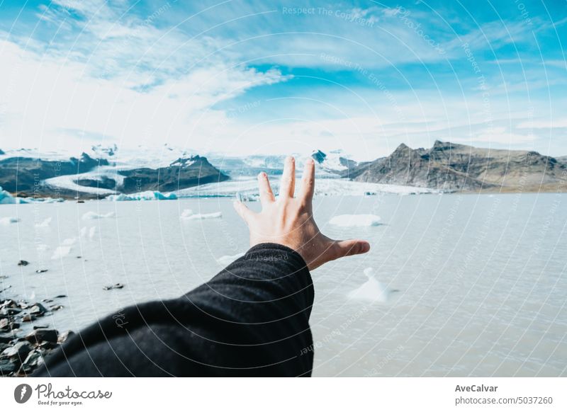 Image of an hand showing in man in front of glacier in iceland, winter travel, cold weather concept. mountain woman journey happiness people hiking adventure