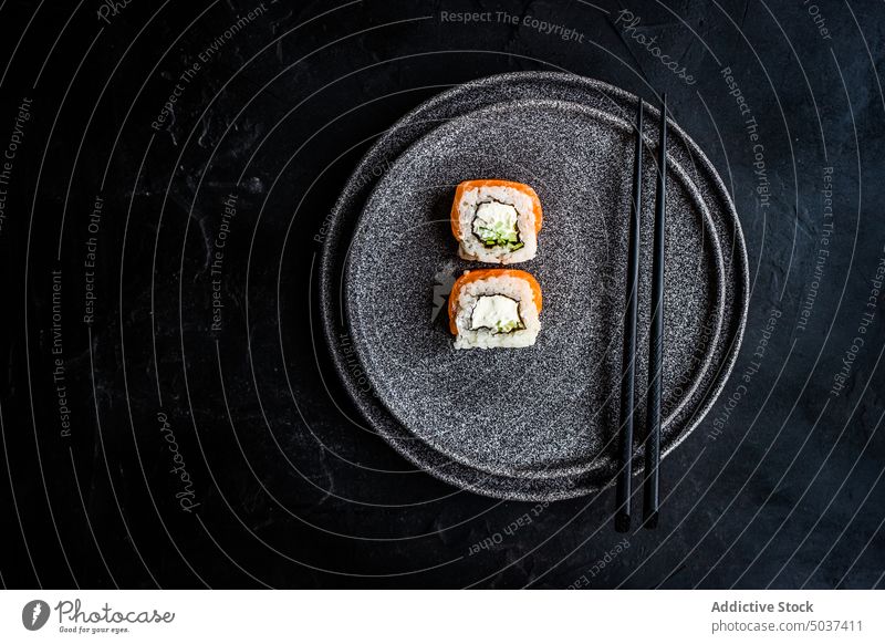 Black stone plate with asian rolls sushi black california roll chopsticks dark eat fish food japan japanese meal minimalism philadelphia roll rice salmon