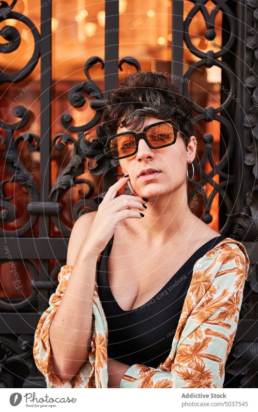 Stylish female against metal gate woman style tourist building historic street ornament weekend brunette madrid spain young outfit sunglasses architecture