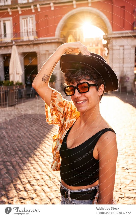 Young brunette on sunlit street at sunset woman smile style happy summer evening portrait madrid spain female young sundown cheerful positive sunglasses