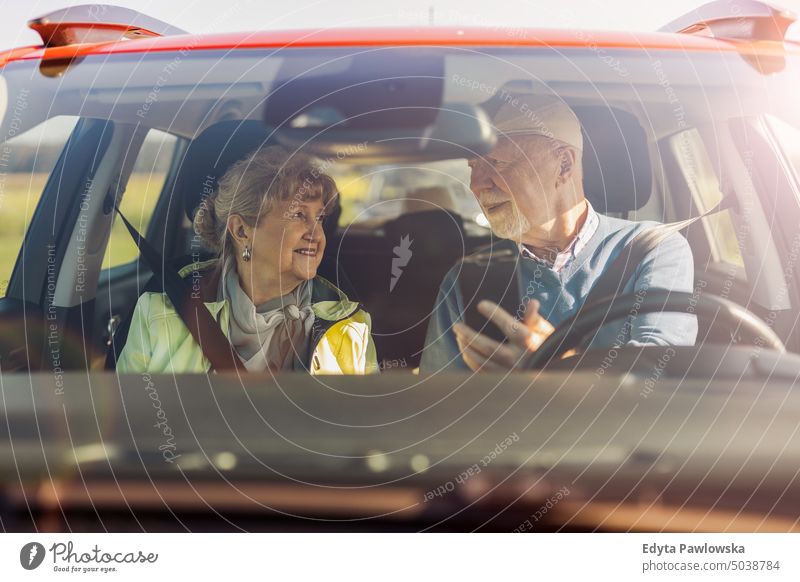 Senior couple using gps on their mobile phone during a road trip voyage Transport Car car Street Car journey travel Trip Adventure Driver Public Holiday