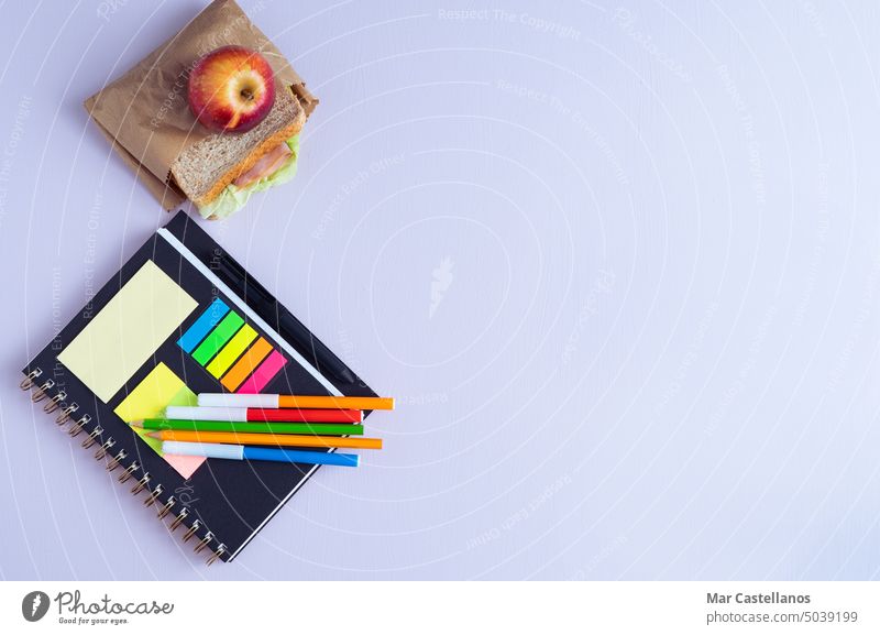 BACK TO SCHOOL with notebook, pencils and sandwich with fruit. study purple background copy space classroom primary secondary top view apple lunch BACK TO CLASS